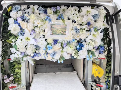 火葬車の中に設えたお花の祭壇と、中央に飾られた虹の橋の絵